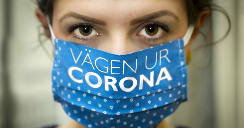 Kvinna med andningsskydd i Vägen ur corona på SVT Play streama