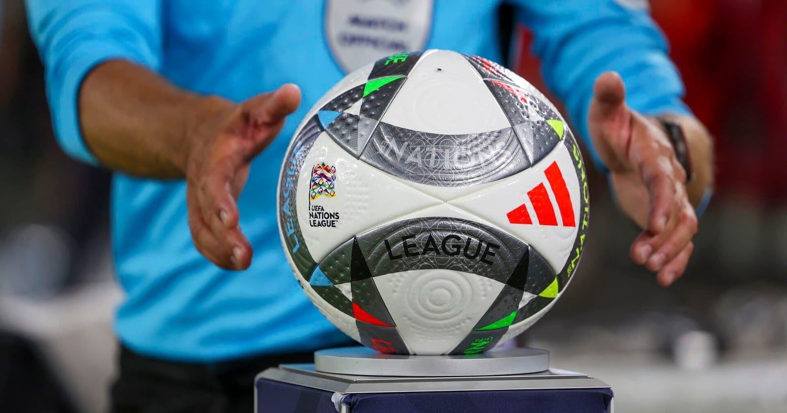 Matchbollen i UEFA Nations League på sitt podium medan domaren sträcker sig efter den